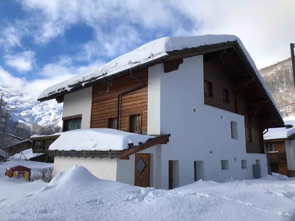 a house with a roof covered in snow at Stilvolle grosszügige 7.5 Zi Maisonette Wohnung 10 Pers in Saas-Fee