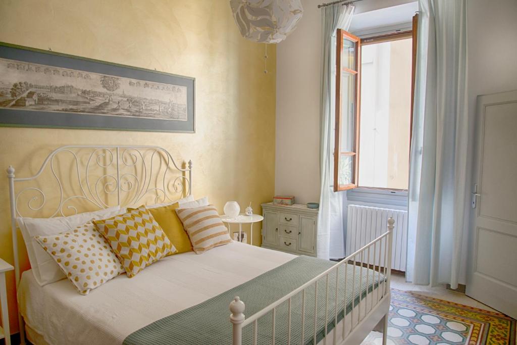 um quarto com uma cama branca e uma janela em La Candida Rosa em Florença