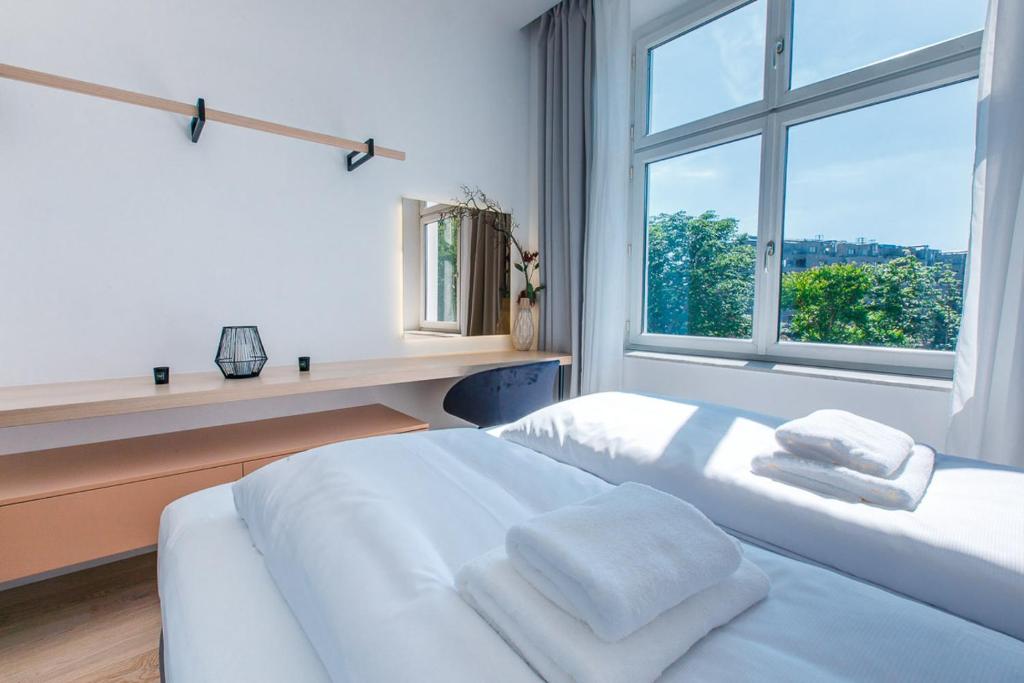 een slaapkamer met 2 witte bedden en een raam bij Zeus Design Apartments Unique #36 in Wenen