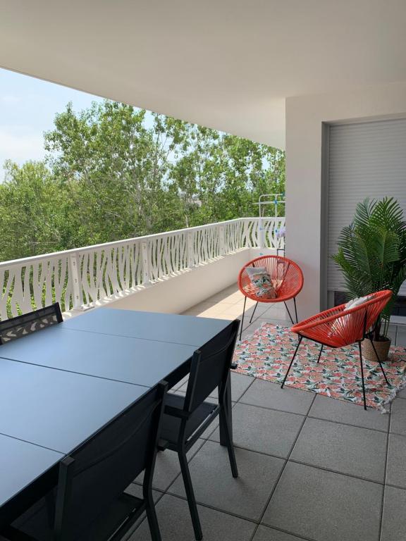 un patio avec une table et des chaises sur un balcon dans l'établissement Les terrasses du port, à Canet