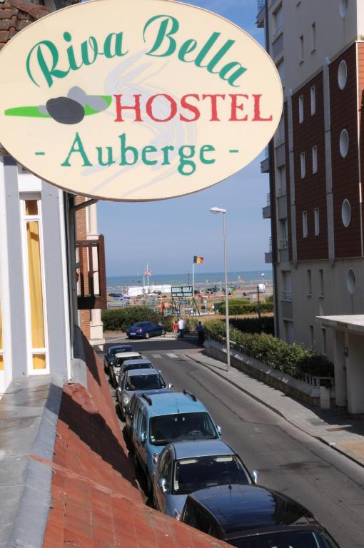 un panneau indiquant un hôtel avec des voitures garées dans une rue dans l'établissement AUBERGE RIVA BELLA, à Le Touquet-Paris-Plage