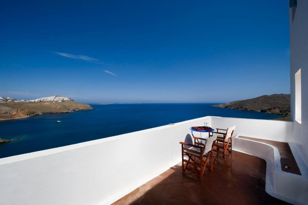 a table and chairs on a balcony overlooking the ocean at Arhitektoniki Studios in Astypalaia Town