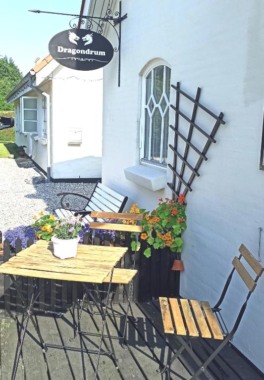 a patio with tables and chairs next to a building at Dragondrum Bed & Kitchen in Ullerslev
