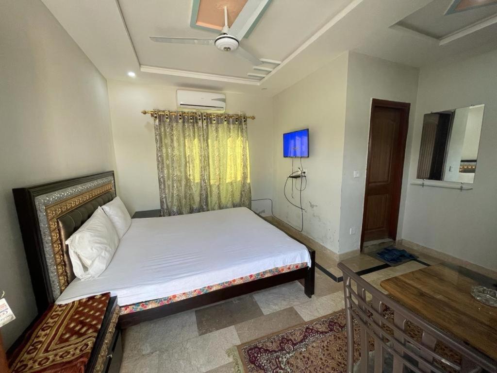 a bedroom with a white bed and a window at Star light in Islamabad