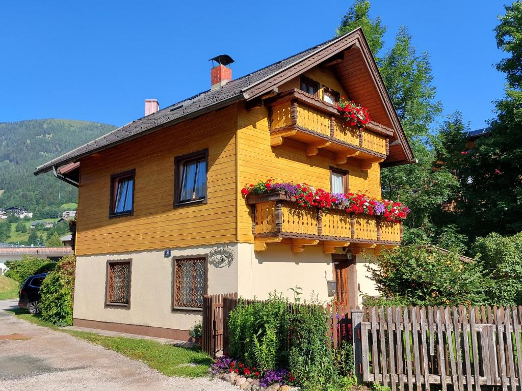 a yellow house with two balconies and flowers on it at CHALET SCHWALBENNEST in Bad Kleinkirchheim