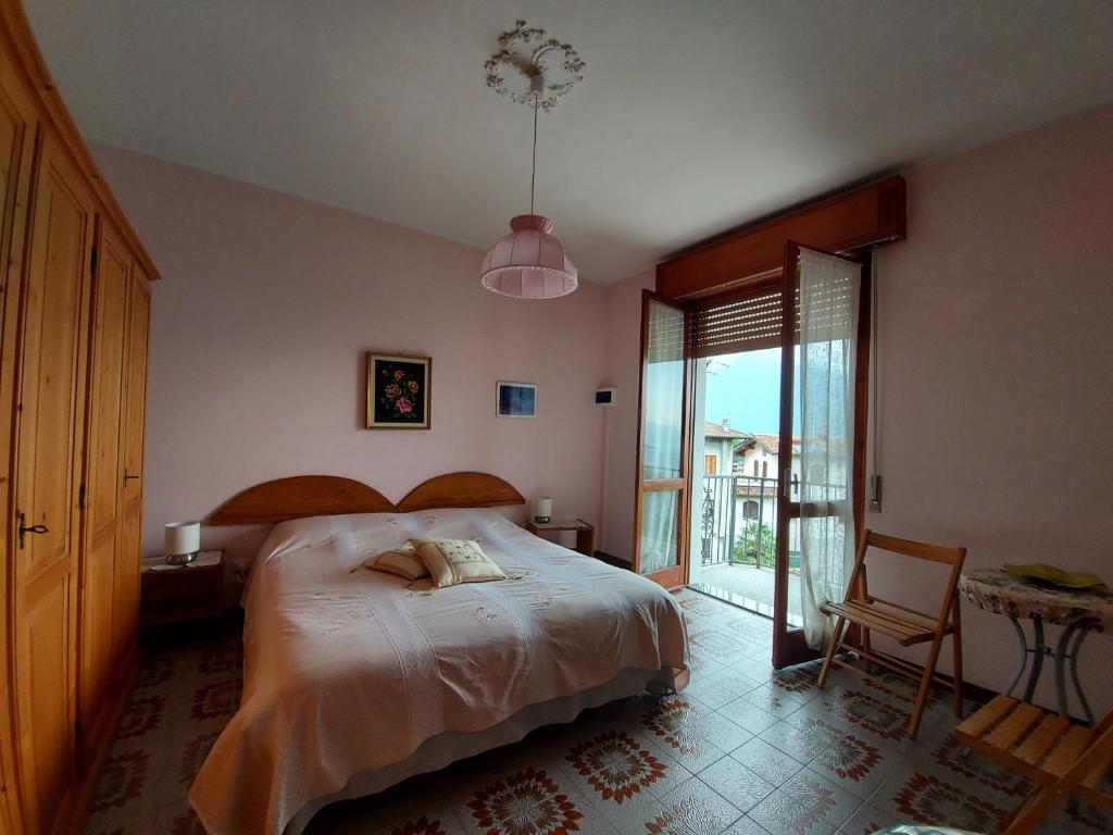 グラヴェドーナにあるCasa Mariaのベッドルーム1室(ベッド1台、椅子、窓付)