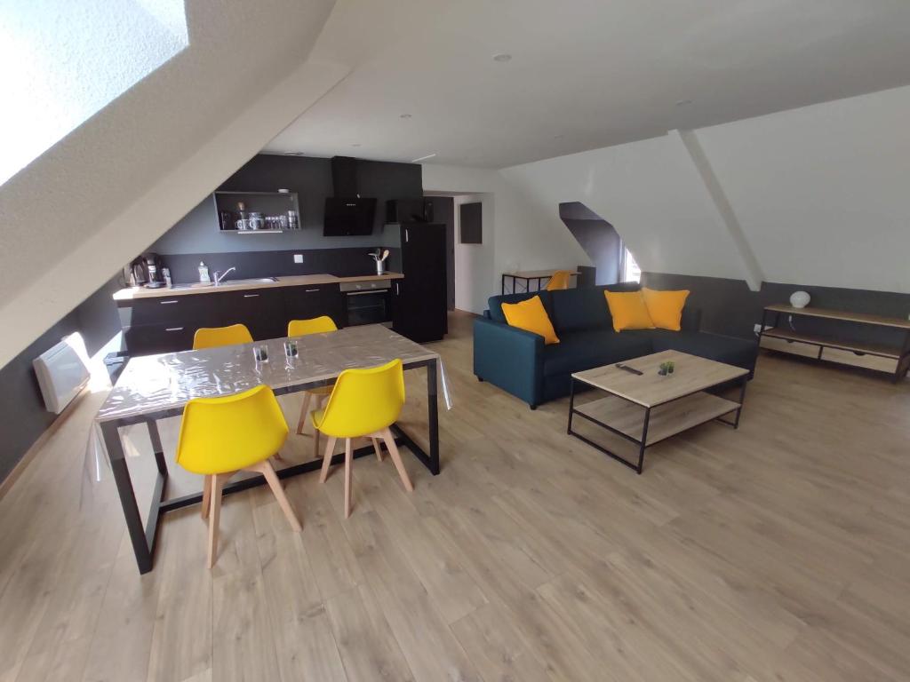 a living room with a couch and a table and yellow chairs at Appartement 5 Cherbourg centre avec NETFLIX et WIFI in Cherbourg en Cotentin