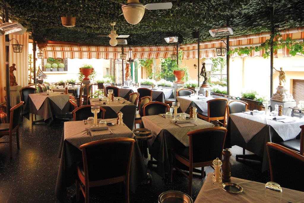 a restaurant with tables and chairs in a room at Locanda Barchetta - Room Rental in Bellagio