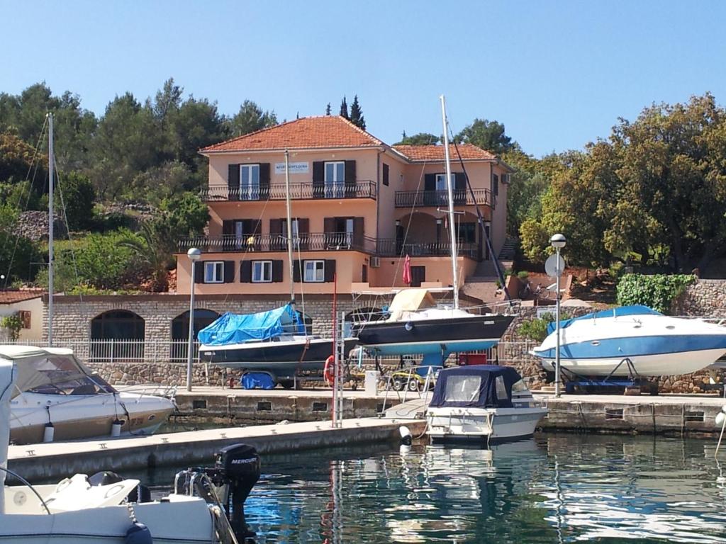a group of boats docked in a marina with a house at Apartments Dora, with a beautiful view of the bay, near the sea and center in Vrboska