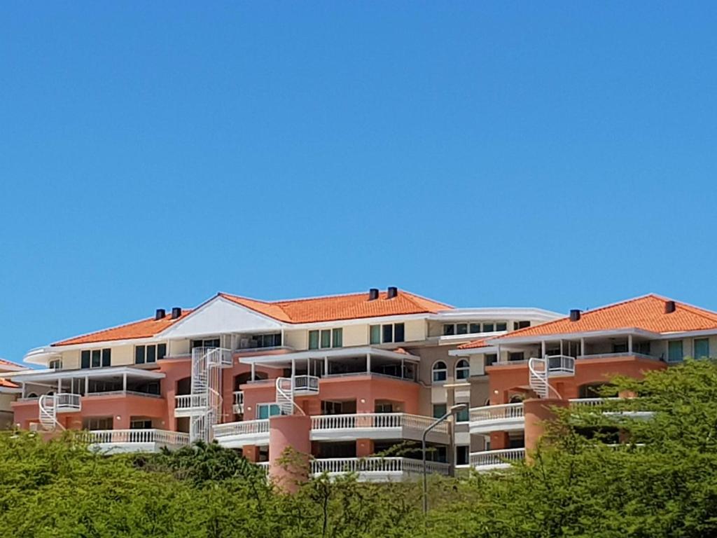 a large apartment building with orange tile roofs at Fabulous ocean view near beaches restaurants in a secured apartment resort in Willemstad
