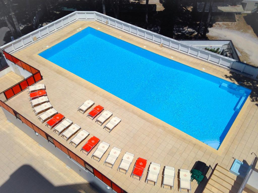 vista sulla piscina con sedie a sdraio e sidx sidx. di Tropicana Residence a Lido degli Estensi