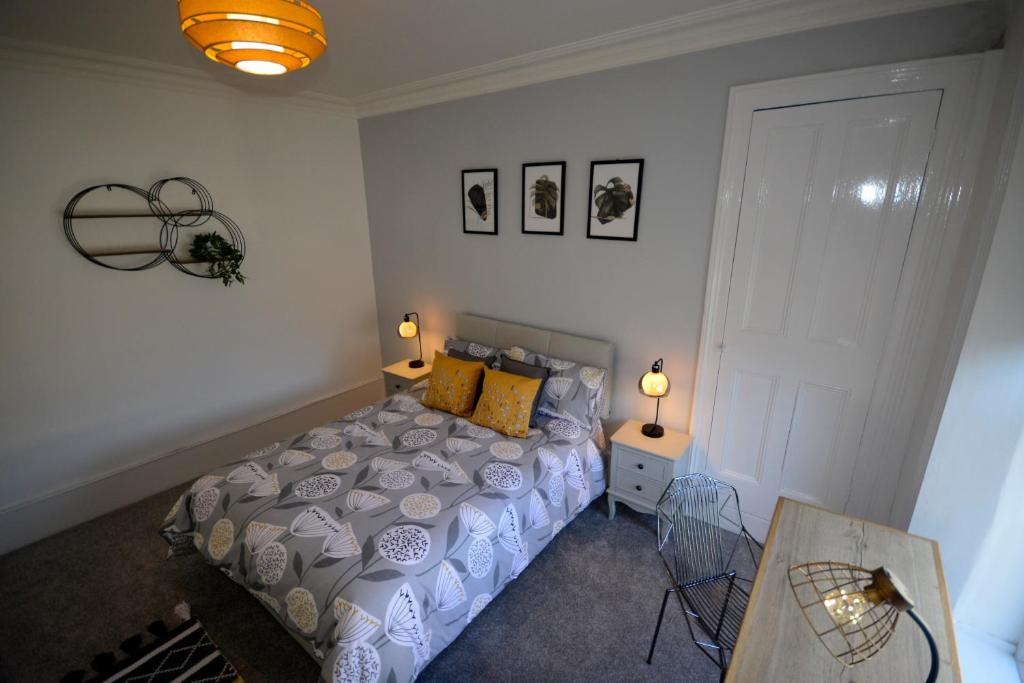 1 dormitorio con 1 cama, 1 mesa y 2 lámparas en Heritage Holiday Accommodation en Pembrokeshire