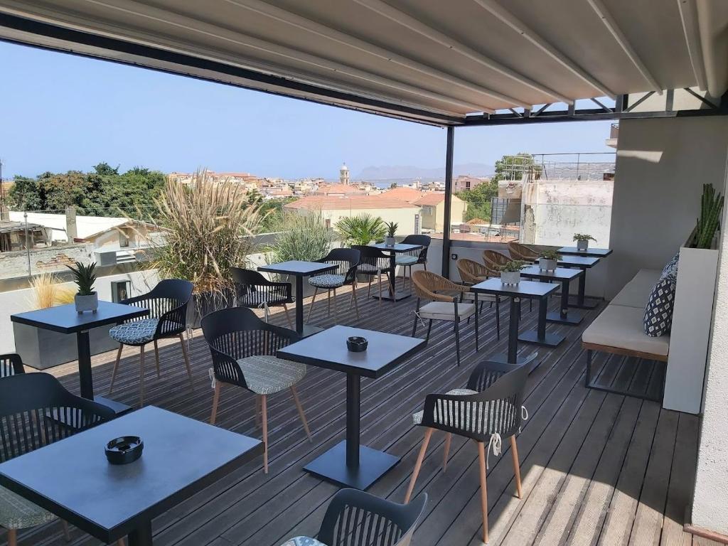 un restaurante con mesas y sillas en una terraza en Central City Hotel, en La Canea