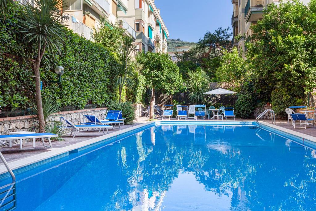 a swimming pool with blue chairs and a building at Estate4Home - Casa Maridea in Sorrento