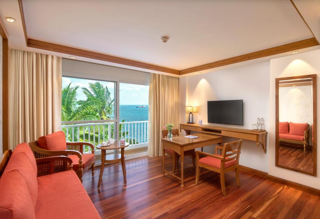 a living room with a couch and a table with a television at Welcomhotel by ITC Hotels, Bay Island, Port Blair in Port Blair