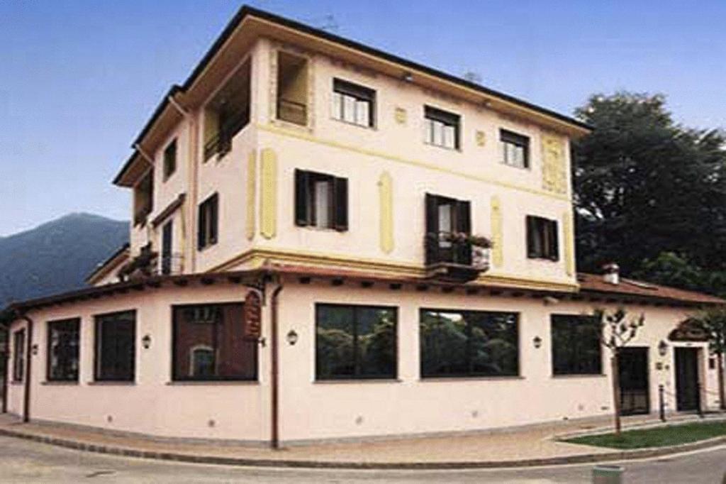 un gran edificio blanco con ventanas en una calle en Hotel La Bussola, en Cittiglio