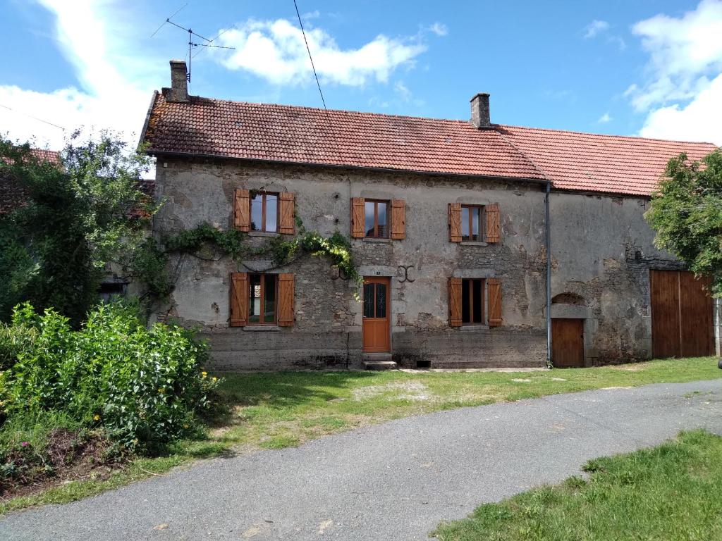 an old stone house on the side of a road at Gite de puy faucher in Arrènes
