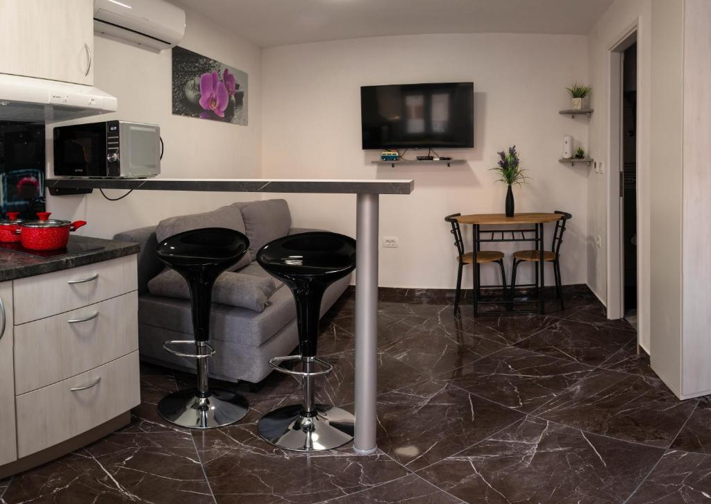a living room with a bar with a couch and a table at Apartman Noel Peroj centar in Peroj