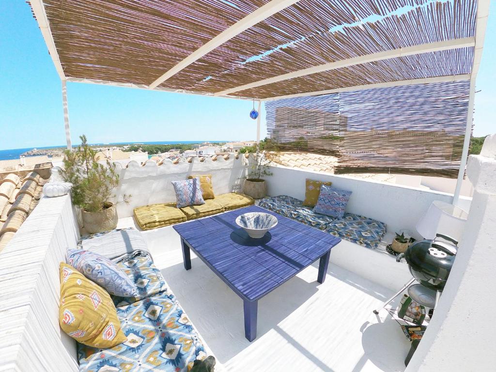 eine Terrasse mit Tisch und Stühlen und dem Meer in der Unterkunft Castell Sol - Arenal Den Castell in Arenal d'en Castell