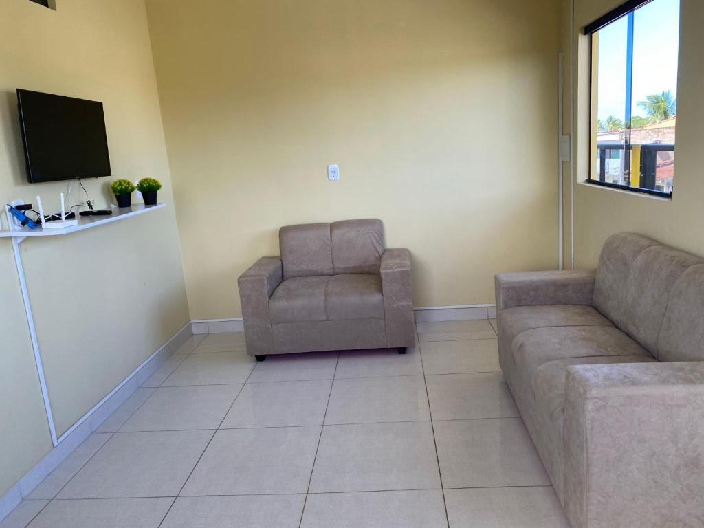 uma sala de estar com um sofá e uma cadeira em Mellim Residence em Maragogi
