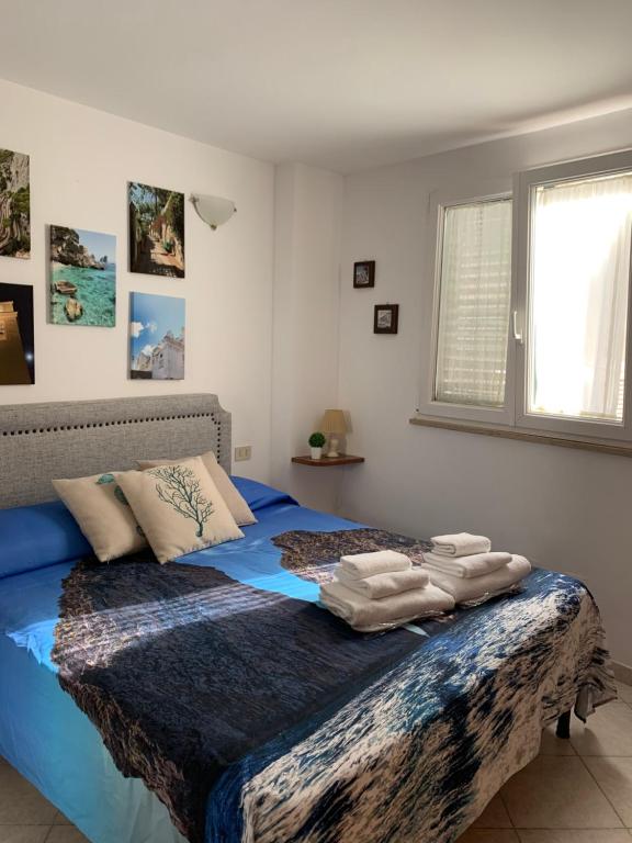 una camera da letto con un letto blu e asciugamani di Casa Ilaria - Appartamento in Piazzetta a Capri