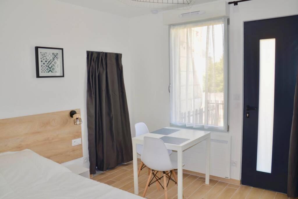 1 dormitorio con escritorio, 1 cama y ventana en Superbe studio idéalement situé ! en Avoine