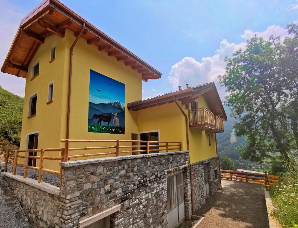 una casa amarilla con una gran pintura a un lado. en Agriturismo Donec, en Villa dʼAllegno