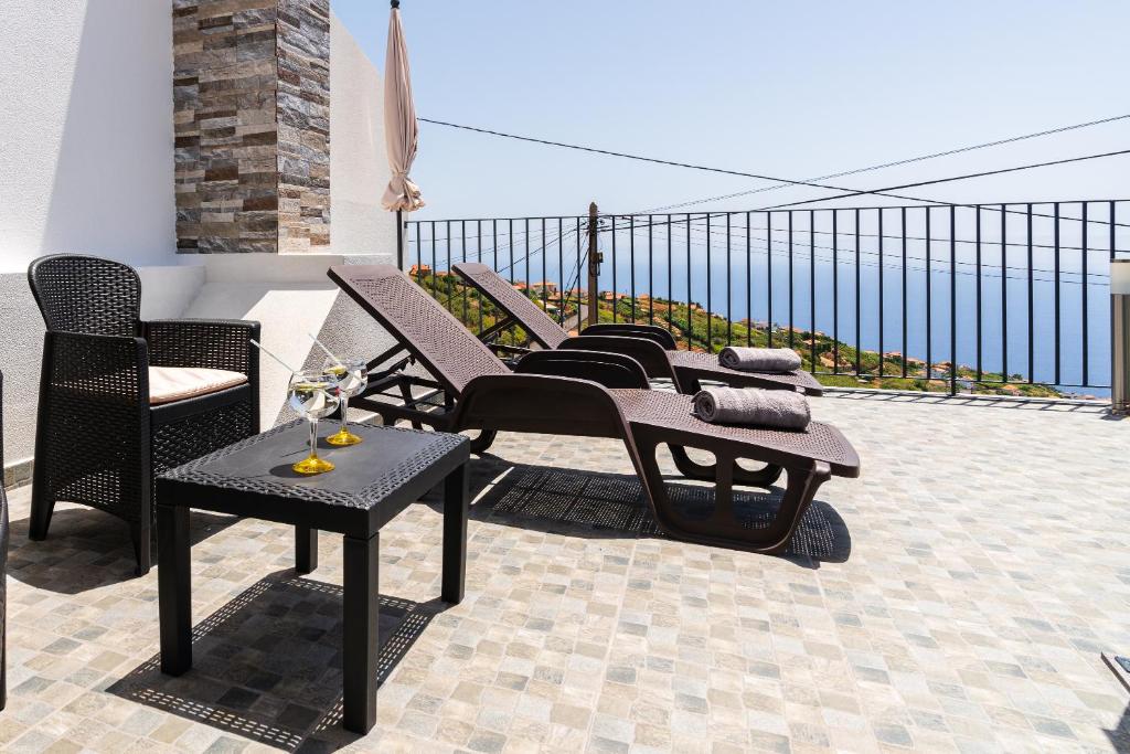 a group of chairs and tables on a balcony at Casa Da Portada in Calheta