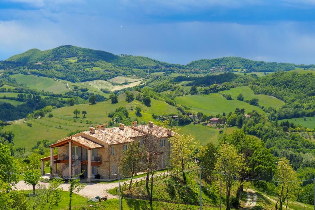 una casa en medio de unas verdes colinas en Country House Ca'Balsomino en Urbino