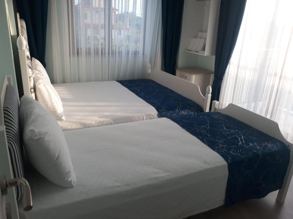 a bedroom with two beds and a window at Geyikli Paris Otel in Canakkale