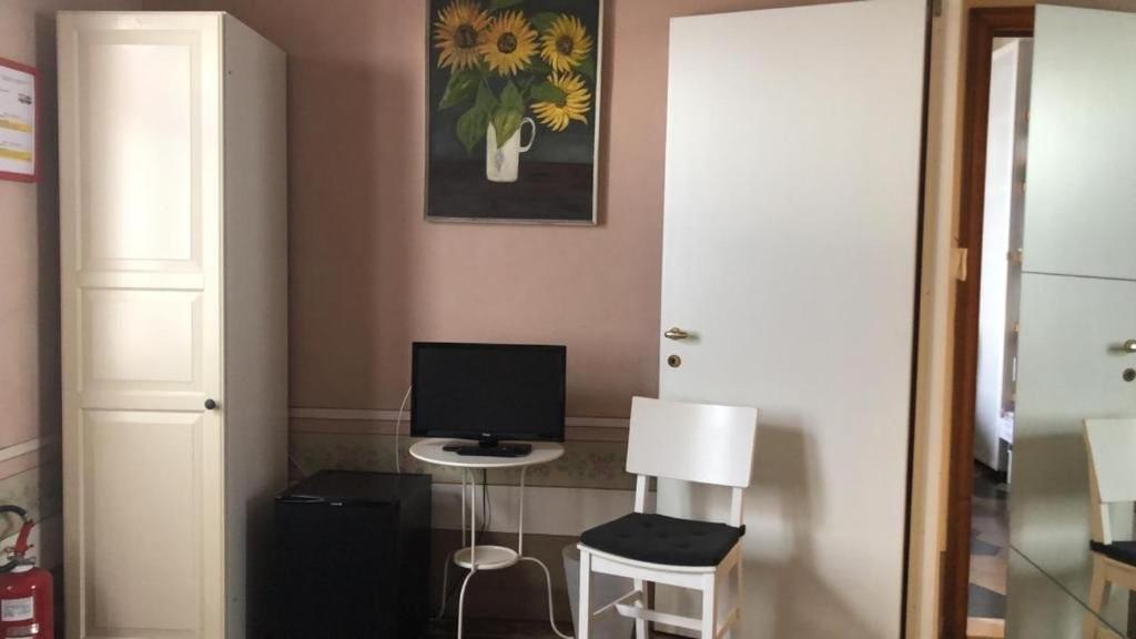 a room with a desk with a computer and two stools at Villino Ermione in Marina di Pisa