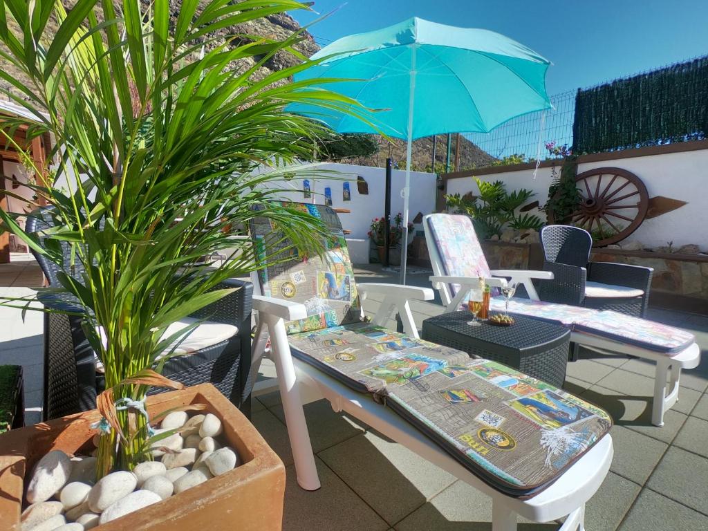 a patio with a table and chairs and an umbrella at Abi&Lei VV in Candelaria