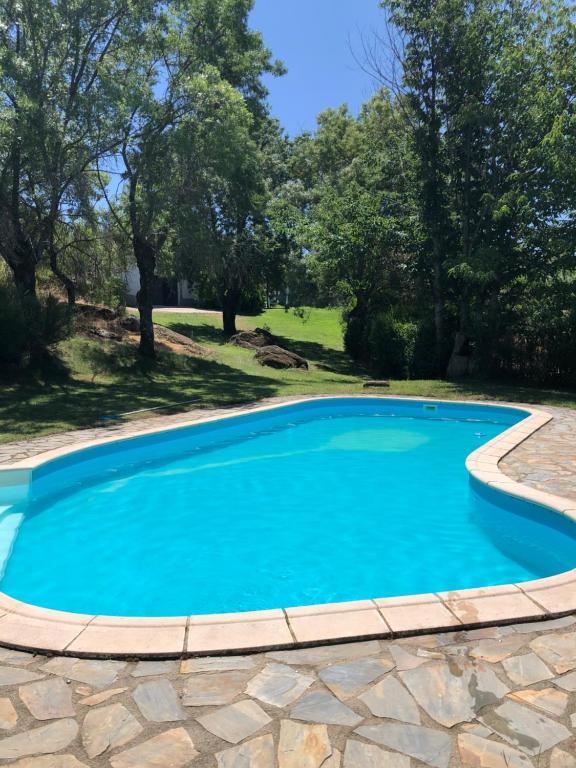 una piscina de agua azul en un patio en Finca La Fresneda en Sierra de Béjar en Navalmoral de Béjar