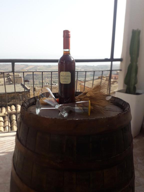 una bottiglia di vino seduta sopra un barile di LA Casa il carretto a Agrigento