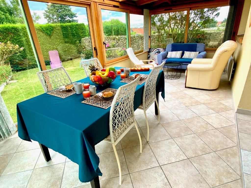 - une table bleue et des chaises dans le salon dans l'établissement Arkas YourHostHelper, à Périers-sur-le-Dan