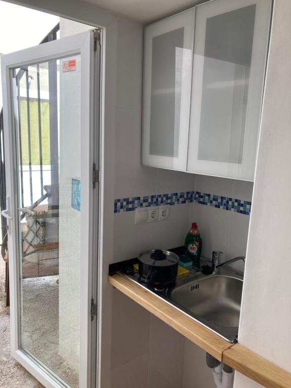 kuchnia z białymi szafkami i zlewem w obiekcie Malagueña Salerosa "Apartamento - estudio con terraza" En casa típica de 1 a 4 dormitorios w Maladze