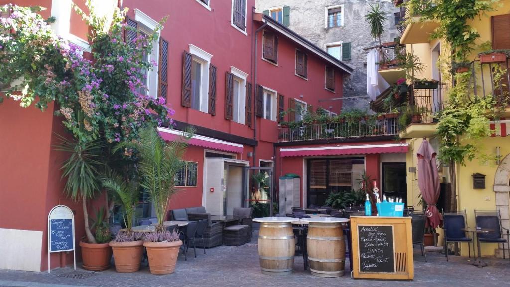 una calle con mesas y sillas frente a los edificios en Hotel Danieli La Castellana lago di Garda, en Brenzone sul Garda