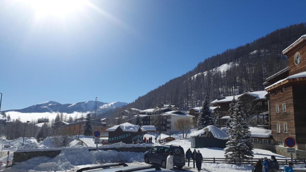 eine schneebedeckte Stadt mit einem Berg im Hintergrund in der Unterkunft appartement cosy central et fonctionnel La Foux d'Allos in Allos