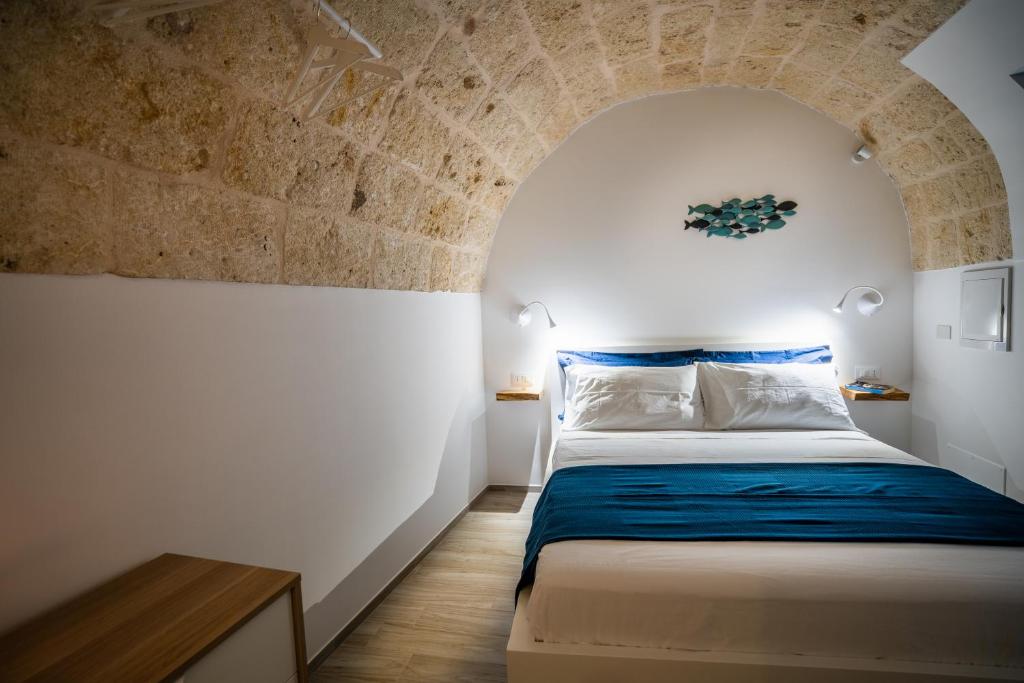 a bedroom with a bed in a brick wall at Vico Blu in Polignano a Mare