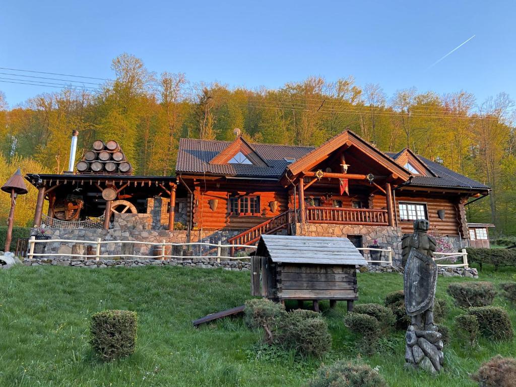 a large log cabin with a statue in front of it at Koliba u Rytiera in Zvolen
