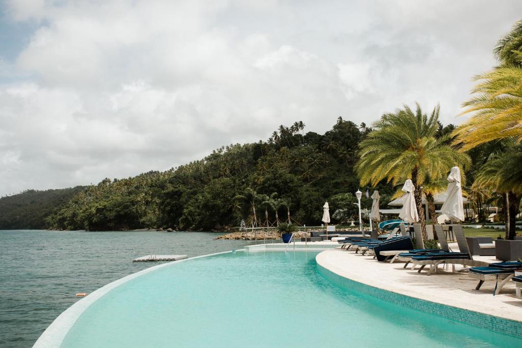 una piscina accanto a un bacino d'acqua di Ocean View Villa/Luxury Puerto Bahia Resort/Samaná a Santa Bárbara de Samaná