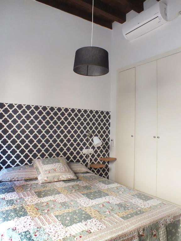 sypialnia z łóżkiem i ścianą wyłożoną kafelkami w obiekcie Apartamento Sevilla Alhondiga w Sewilli