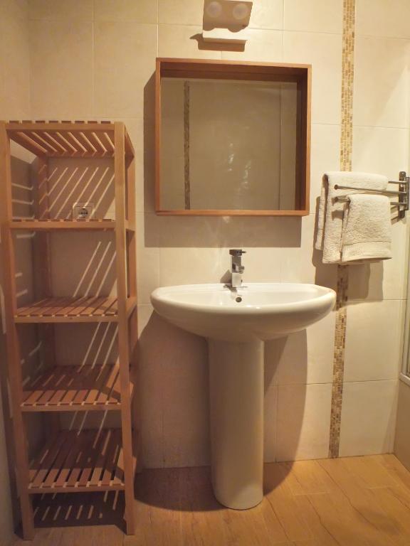 łazienka z umywalką, lustrem i półkami w obiekcie Apartamento Sevilla Alhondiga w Sewilli