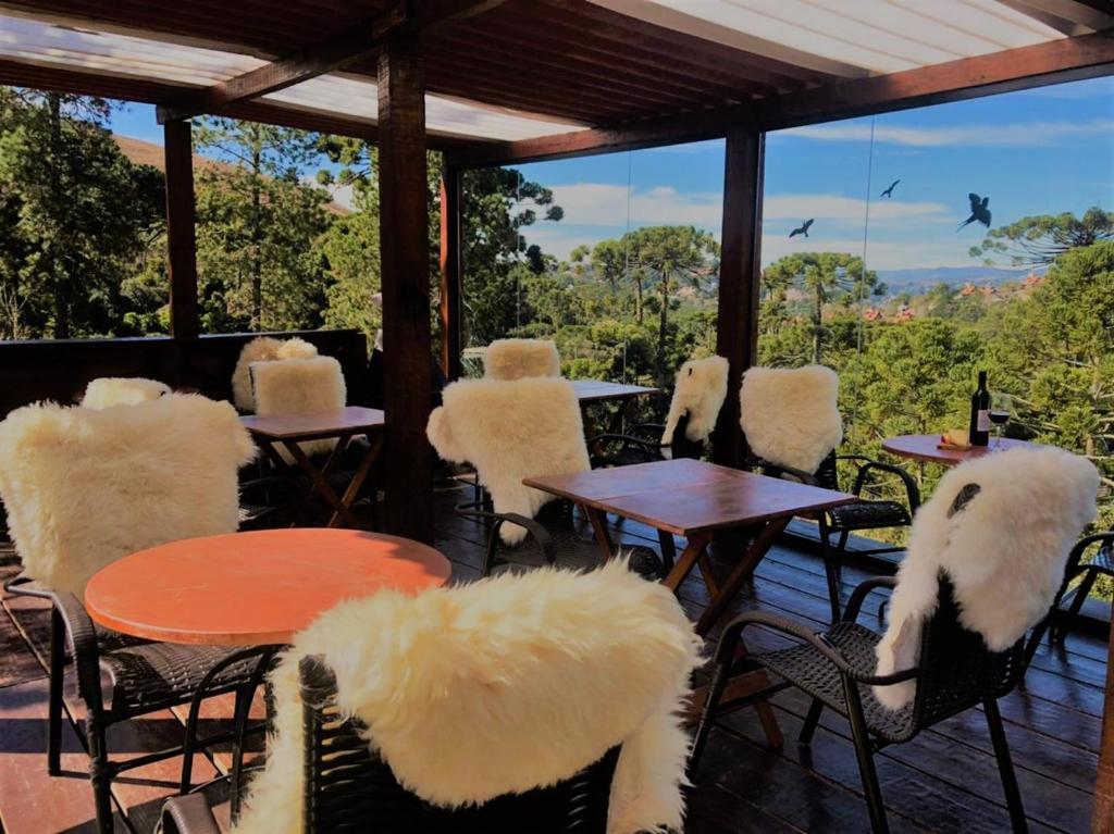 a group of chairs and tables on a deck at Cantinho de Campos in Campos do Jordão