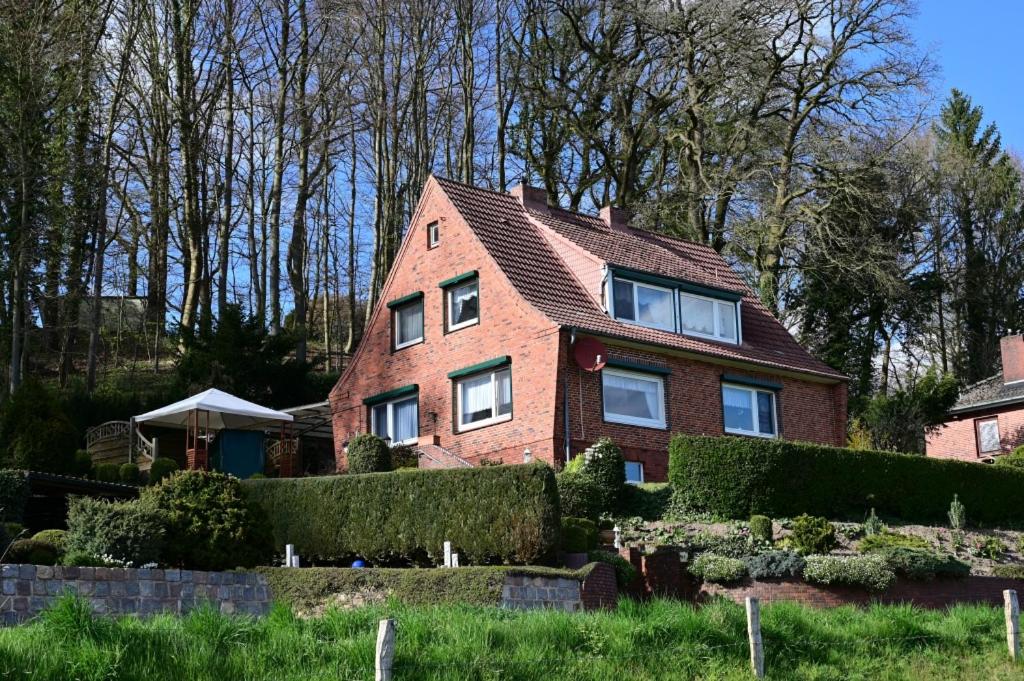 a red brick house with bushes in front of it at Haus Lisa Burg Dithmarschen am Nord Ostsee Kanal Nordsee in Burgerfeld