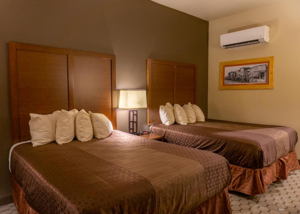 um quarto de hotel com duas camas com almofadas brancas em Newcastle Lodge & Convention Center em Newcastle