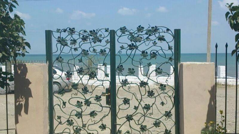 a gate with a wrought iron fence in front of the beach at Nabran Ojag resort in Aşağıoba