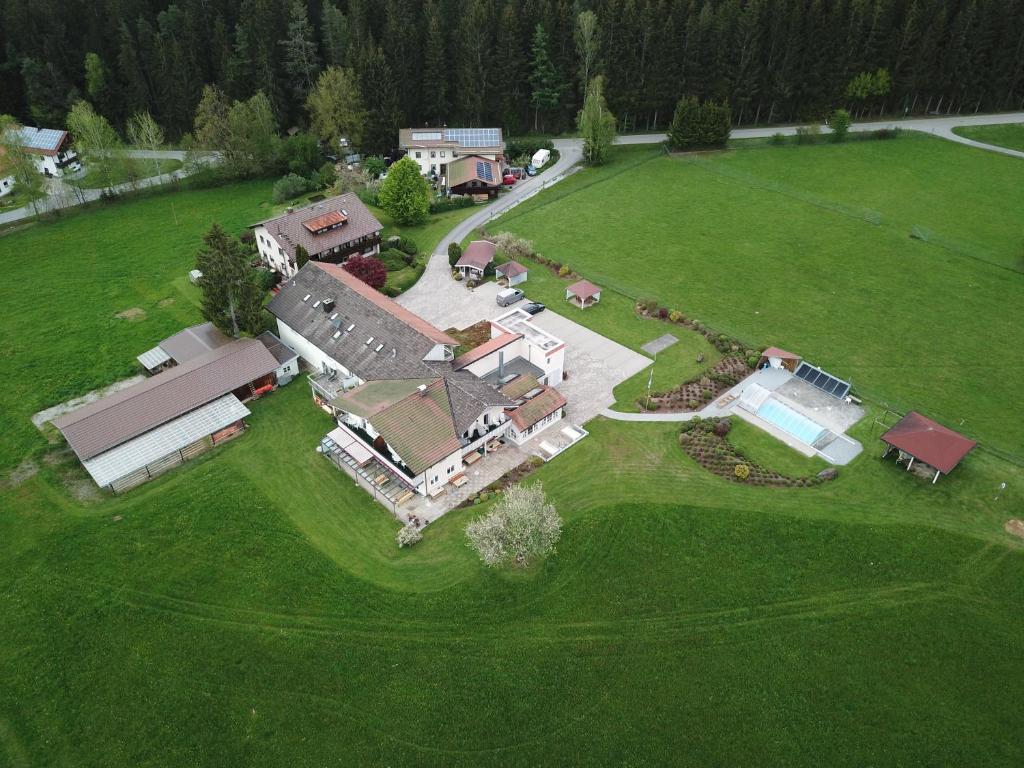 eine Luftansicht eines großen Hauses auf einem Feld in der Unterkunft Pension Waldblick in Böbrach