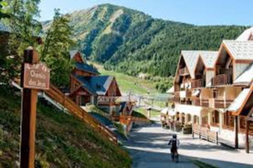 a person riding a bike down a street in a village at Oz Appartement cosy 3 chambres in Oz