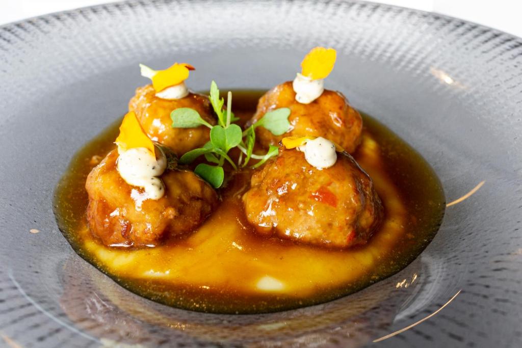 a plate of food with chicken in a sauce at Hotel Gastronómico Torre de Galizano in Galizano